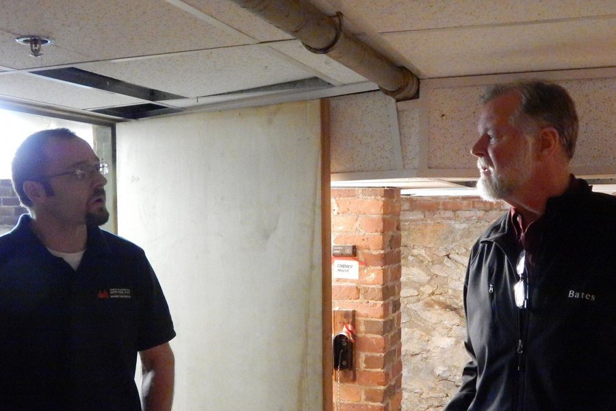 Aaron MacFawn of Maine Controls, at left, confers with Bates energy manager John Rasmussen in the basement of Cheney House after the installation of remote heating controls and sensors on Nov. 15. (Doug Hubley/Bates College)