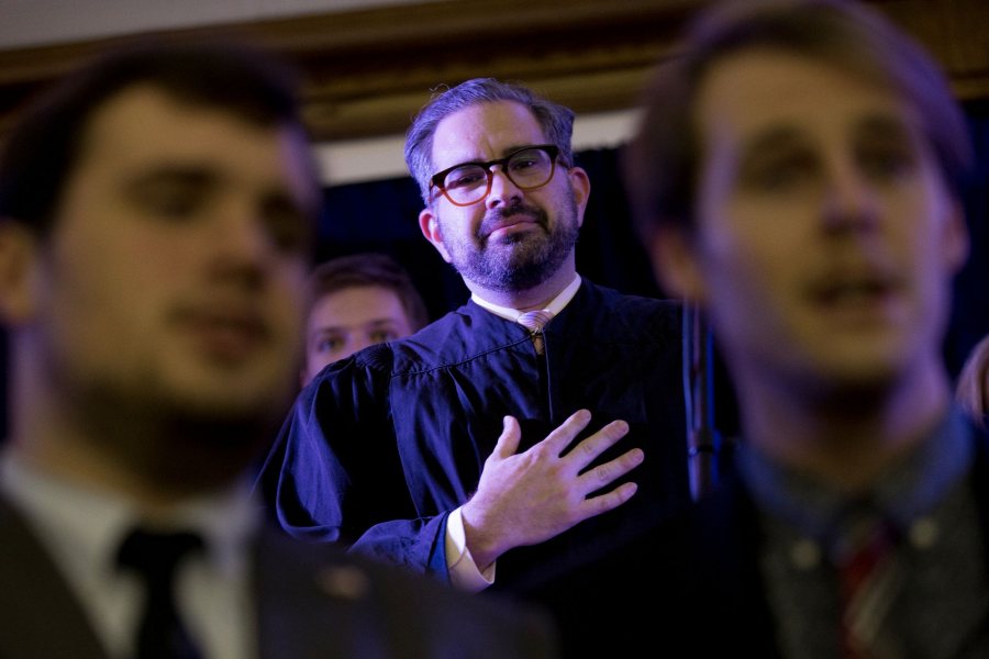 Associate Professor of Politics Stephen Engel places his hand over his heart as the Manic Optimists sing the national anthem in Memorial Commons. Dressed as a Supreme Court justice, Engel swore in the new U.S. president, Gabriel Nott '17, who then delivered his vision for America in his inaugural address. It was all the culmination of the mock presidential election for the course “Presidential Campaign Rhetoric." (Phyllis Graber Jensen/Bates College) 