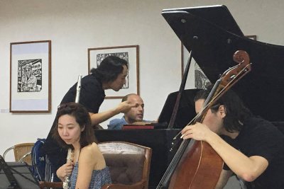 Hiroya Miura consults with Third Sound pianist Orion Weiss as four members of the ensemble rehearse Miura's "Open Passage" in Havana. Also shown are flutist Sooyun Kim and cellist Michael Nicolas; out of the frame is violinist Adda Kridler. (Courtesy of Hiroya Miura)