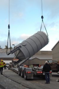 Up, up, and away, or at least over a few yards: Two Cote cranes orient the RFO tank upright prior to placing it. (Doug Hubley/Bates College)