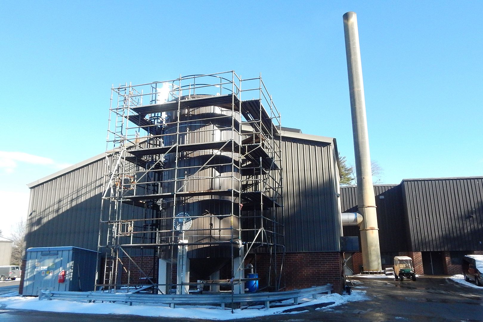 Surrounded by scaffolding and newly clad in siding to match the adjacent Cutten Maintenance Center, the Renewable Fuel Oil tank is shown on Jan. 19, 2017. (Doug Hubley/Bates College) 