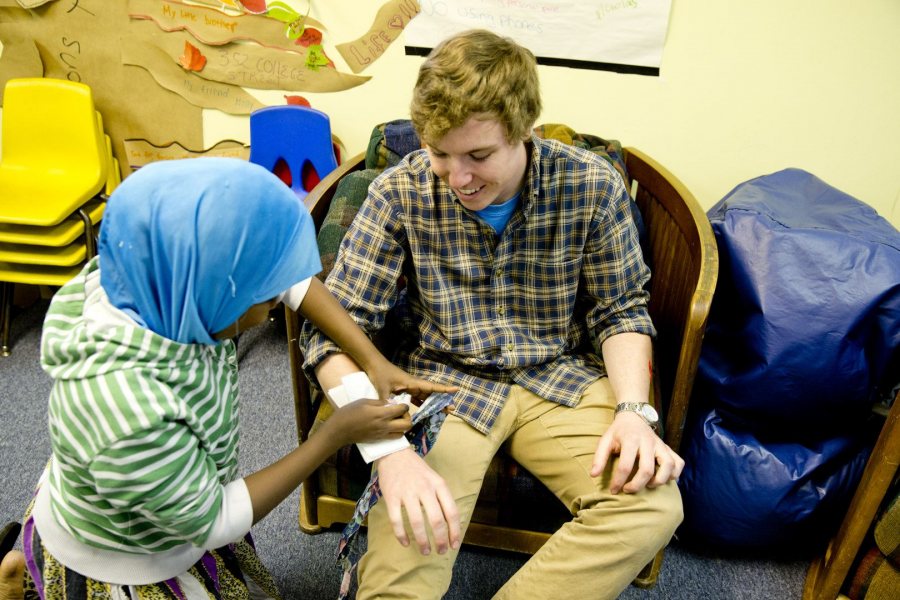 Bill Curley '16 of Wilton, Conn., works with a participant in a session of the "How Everything Works" program at the Hillview Community Resource Center. Held in February 2016, the session explored first aid practices. (Phyllis Graber Jensen/BAtes College)