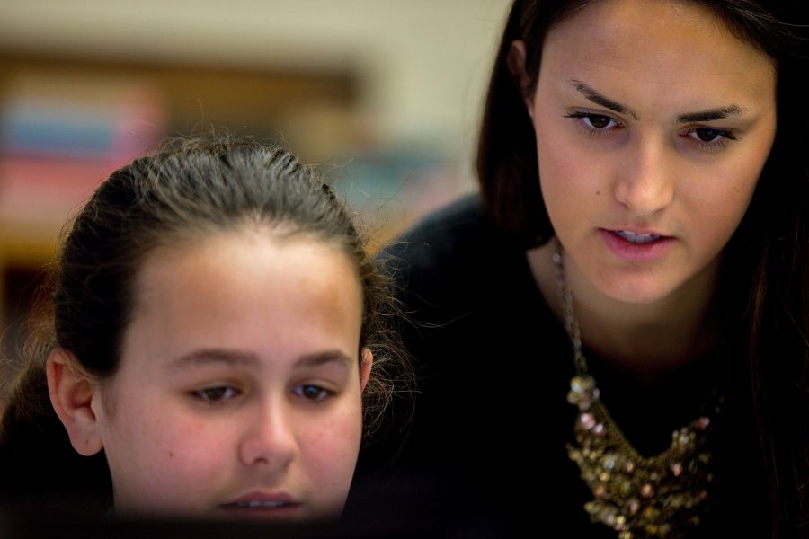 Student teacher Elizabeth Erbafina '17 consults with a seventh-grade literacy student. (Phyllis Graber Jensen/Bates College)