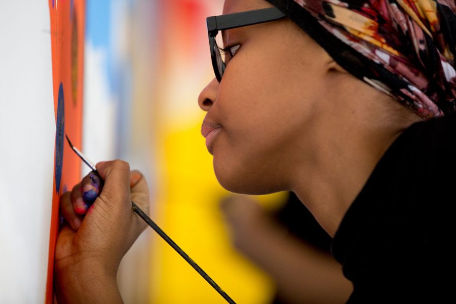 An unidentified Lewiston High School student, a member of the 21 Century Leaders program, does detail work on the YWCA mural. (Phyllis Graber Jensen/Bates College)