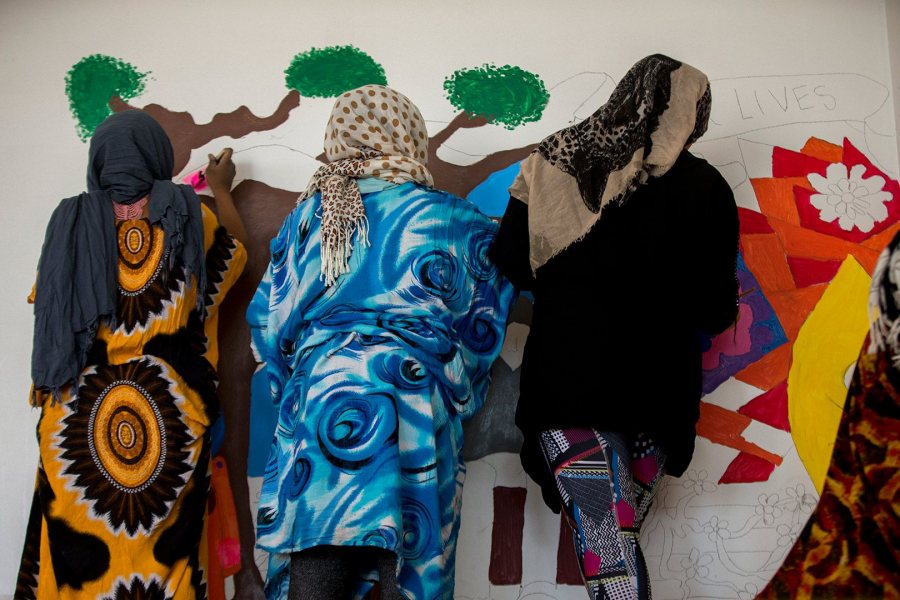 Unidentified Lewiston High School students, all members of the school's 21st Century Leaders program, paint the YWCA mural on March 26. (Phyllis Graber Jensen/Bates College)