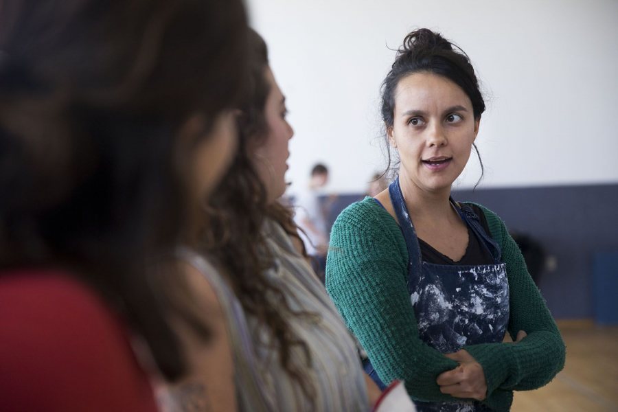 Carolina Gonzalez Valencia, a lecturer in art and visual culture, talks with her Bates students as they work on the YWCA mural on March 26. (Phyllis Graber Jensen/Bates College) 