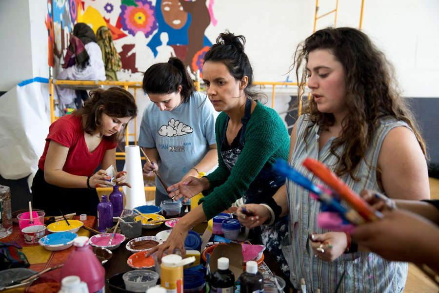 From left, Daisy Diamond '19, Eden Rickolt '20, Carolina Gonzalez Valencia, a lecturer in art and visual culture, and Dani Klein '17 mix colors for the "Women of Color Leading Change" mural. Phyllis Graber Jensen/Bates College)