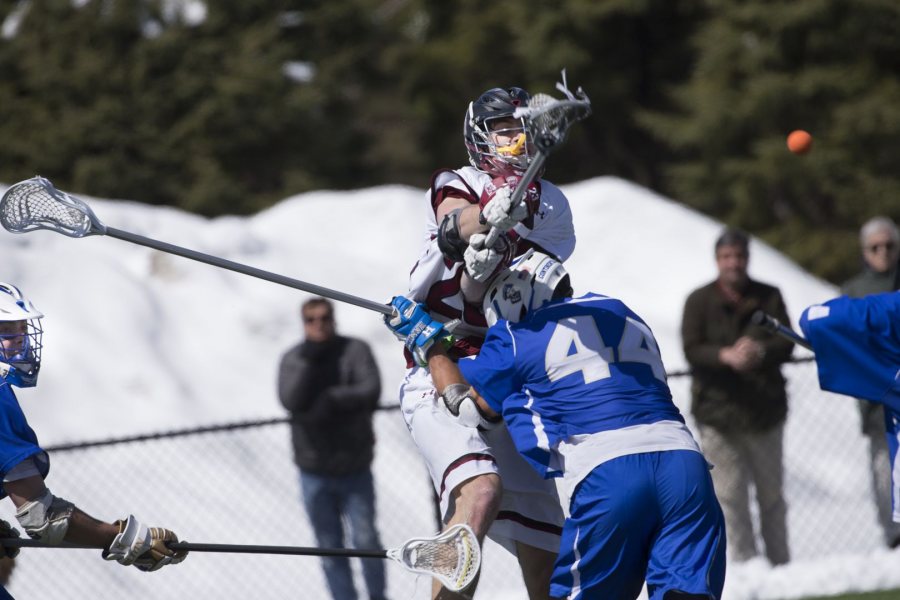 Charlie Fay ’17 of Falmouth, Maine, takes a hit en route to scoring five goals with one assist during the Bobcats’ victory over Hamilton at Garcelon Field. (Phyllis Graber Jensen/Bates College)