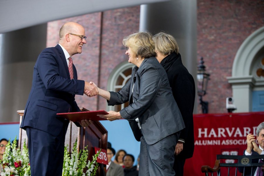 Phillip Lovejoy, executive director of the Harvard Alumni Association, presents Bates President Clayton Spencer with the association's Harvard Medal on May 25. Behind Spencer is Harvard president Drew Faust. The HAA's annual meeting took place in Tercentenary Theatre, Harvard, during the afternoon program of Harvard's Commencement. (Rose Lincoln/Harvard University)