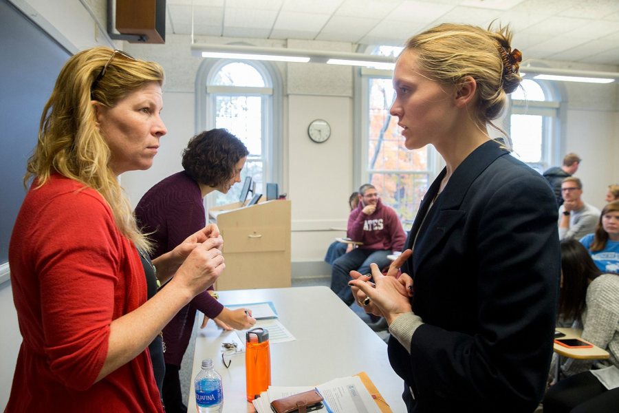 Associate Professor of Rhetoric Stephanie Kelly-Romano, at left, confers with Molly Chisholm during the fall 2017 course "Presidential Campaign Rhetoric." As Chisholm has honed the Senior Address she'll be giving May 28 at Commencement, Kelley-Romano has been a valued adviser. (Phyllis Graber Jensen/Bates College)