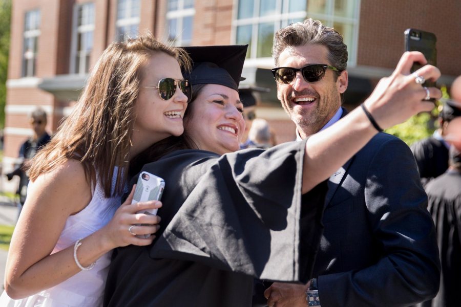 Kate Berger '17 (center) and classmate Sadie James take a selfie with actor and Bates honorand Patrick Dempsey as graduates line up on Alumni Walk. Berger, whose twin sister heard a former vice president speak at Colby College's graduation last week, commented, "This beats Joe Biden." (Phyllis Graber 