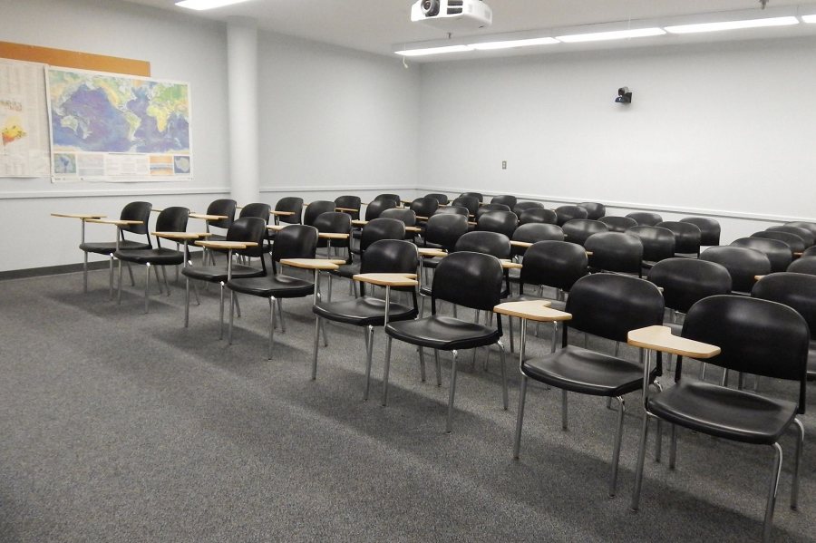 Carnegie 225 in mid-June 2017. During the summer, whiteboards will be installed around the room, the tablet-arm desks will be replaced with node chairs, and a window will be placed to the right of the pillar. (Doug Hubley/Bates College) 