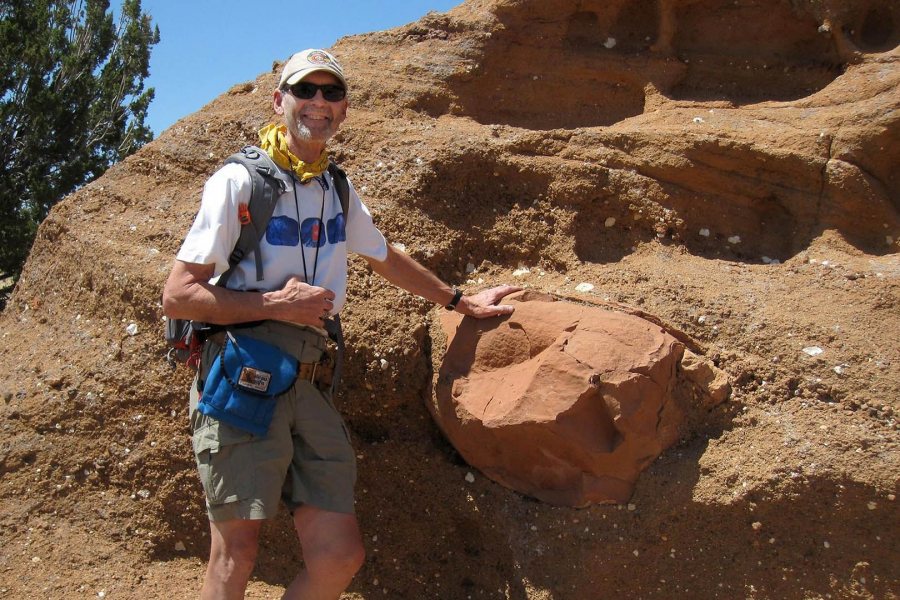 Near Flagstaff, Arizona, in 2011, on his final Short Term trip to the U.S. Southwest, John Creasy poses next to examples of "volcaniclastic" rock that's been moved or affected by wind, water, or similar action. (Photograph by Dykstra Eusden '80)