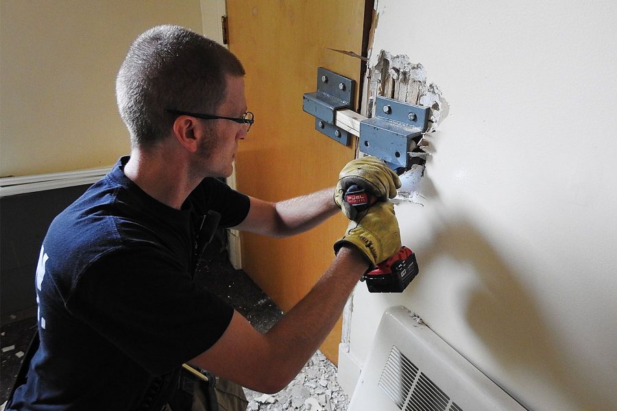 Lewiston firefighter Eric Watson, the training leader on July 18, secures a door in Holmes House for forcible-entry training. (Jay Burns/Bates College)