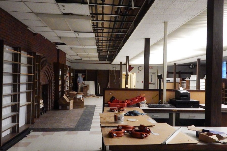 The black pipes at top center will carry water from the Chase Hall mechanical room to fan-coil units that will heat and cool the Den and Memorial Commons. Project manager John Rasmussen is standing by the fiction section of Bates' former bookstore. (Doug Hubley/Bates College) 