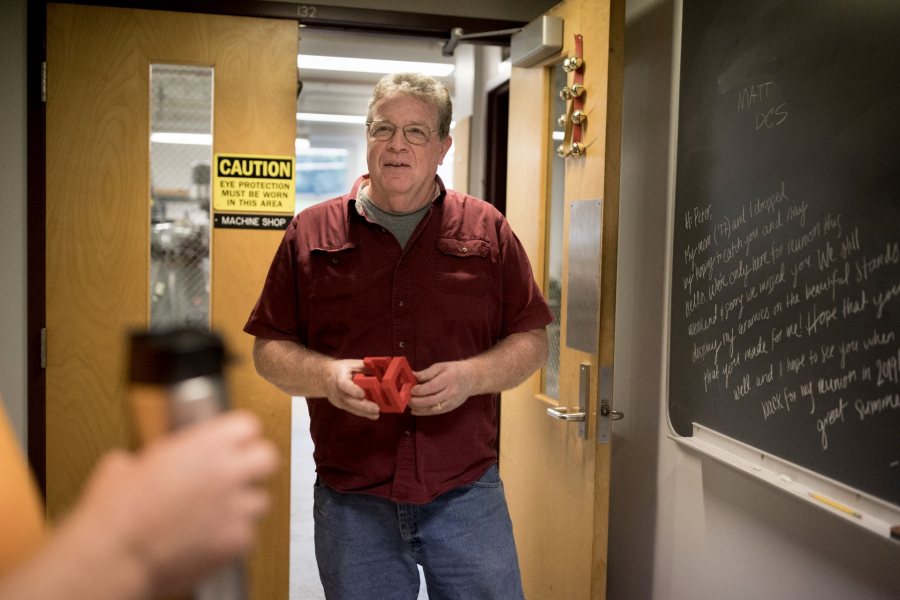 Machinist Peter Beach discusses an upcoming project with a professor outside his Carnegie Science shop. (Phyllis Graber Jensen/Bates College)