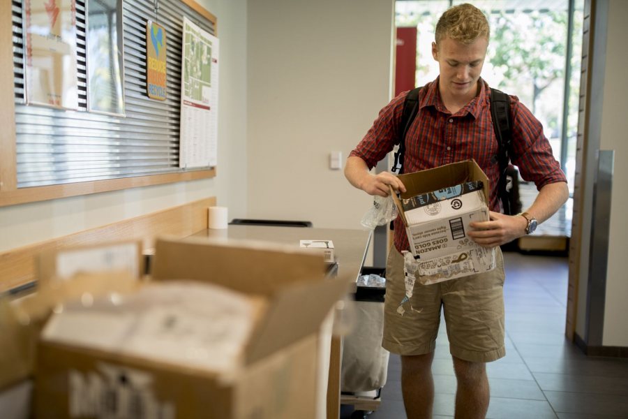 Joe Inger '21 opens a new pair of earbuds in Post & Print on Oct. 10. (Phyllis Graber Jensen/Bates College)