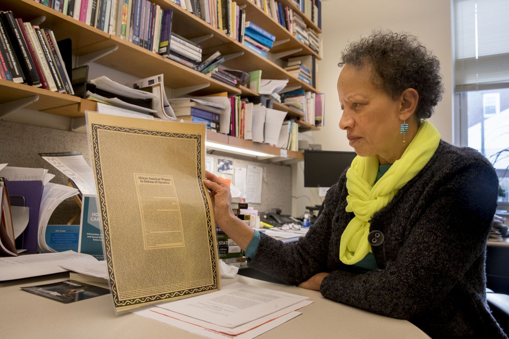 Associate Professor of Politics Leslie Hill inspects "African American Women in Defense of Ourselves." (Phyllis Graber Jensen/Bates College)