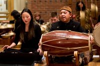 Bates artist-in-residence Darsono, at right, is shown Chaesong Kim '18 of Goyang-si, South Korea, during a Bates Gamelan Orchestra performance in the Benjamin Mays Center in December 2017. (Phyllis Graber Jensen/Bates College)