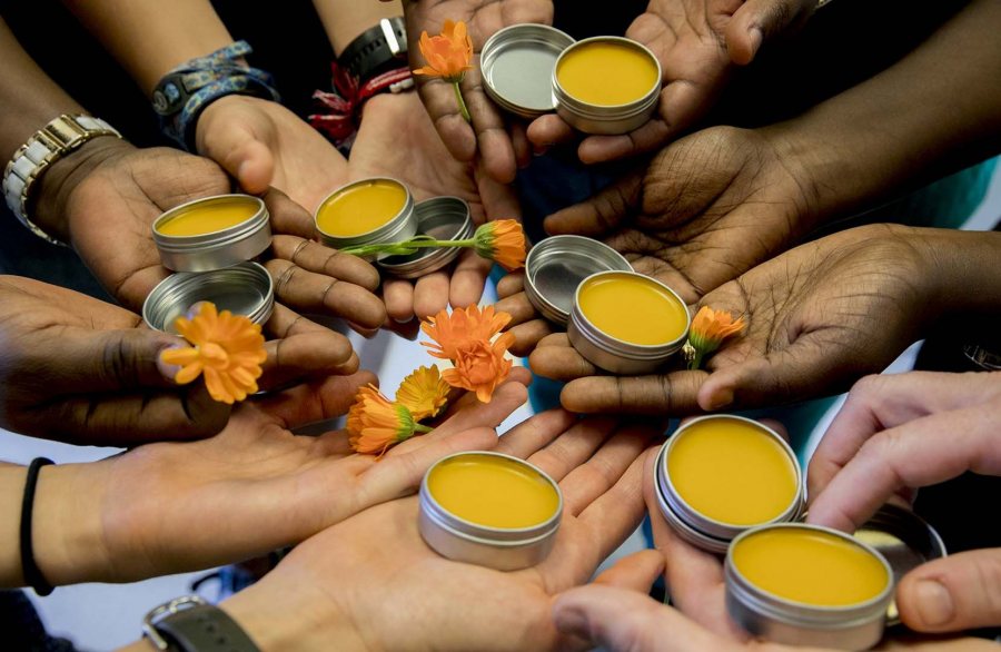 Participants in the Herban Works business at Lewiston's Center for Wisdom's Women show off a calendula salve in 2017. Herban Works was a 2019 Carignan Grant recipient. (Phyllis Graber Jensen/Bates College)