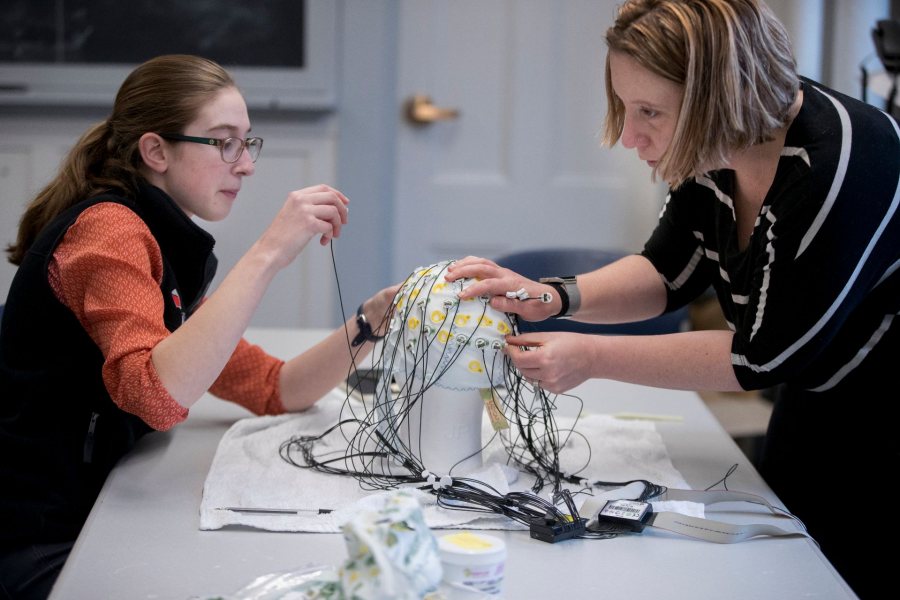 Sarah Rothmann '19 of Andover, Mass., participates as a subject in an EEG neuroscience thesis experiment for a first-person story she is writing for the Bates Communications Office. Hanna De Bruyn ‘18, Old Lyme, Conn., is the thesis student who is working on the supervision of Michelle Greene, assistant professor of neuroscience in the Bates Computational Vision Lab (Hathorn 108). “We are piloting the experiment for these students’ thesis experiments. They were piloting Hanna’s experiment. She’s interested in looking at the extent to which visual masking actually inhibits perception. So when you take a visual mask, you take an image followed by another image, you’re impaired at understanding the first image. The question is why. So what we’re going to do is take the neural activity that we’re measuring. And the nice thing about EEG is that it measures millisecond by millisecond electrical potentials that are generated in the brain , we measure them from the scalp. And we can see over time what the brain is processing and we use machine learning, we put these signals into a computer system tha t reads out the extent to which there is information about what the picture is. We’re wondering, does that information persist when you change the image? Does that persist over time? Hannah’s made the experiment, and we are going to try it out to make sure everything’s ready for participants.” -- Michelle Greene, assistant professor of neuroscience, says of three thesis students in neuroscience: “They’re all terrific, I might add.” Hanna De Bruyn ‘18, Old Lyme, Conn. Katherine “Katie” Hartnett ’18 of St. Paul, Minn., and Julie Self ’18 of Redwood City, Calif. Hanna is the only student to appear in this set of pictures.