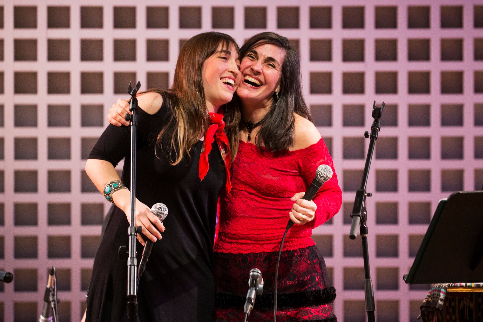 Alisa Amador '18 of Cambridge, Mass., and her mother, Rosi Amador, embrace during a performance by the group Sol y Canto, whose principals are Alisa's parents, Rosi and Brian. Alisa joined them for the Olin Concert Series event. (Theophil Syslo/Bates College)