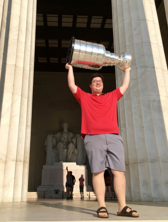 Tim Ohashi '11, a member of the NHL championship Washington Capitals coaching staff, hoists the Stanley Cup at the Lincoln Memorial on the morning of July 3, 2018. (Photograph by Walt Neubrand / Hockey Hall of Fame)