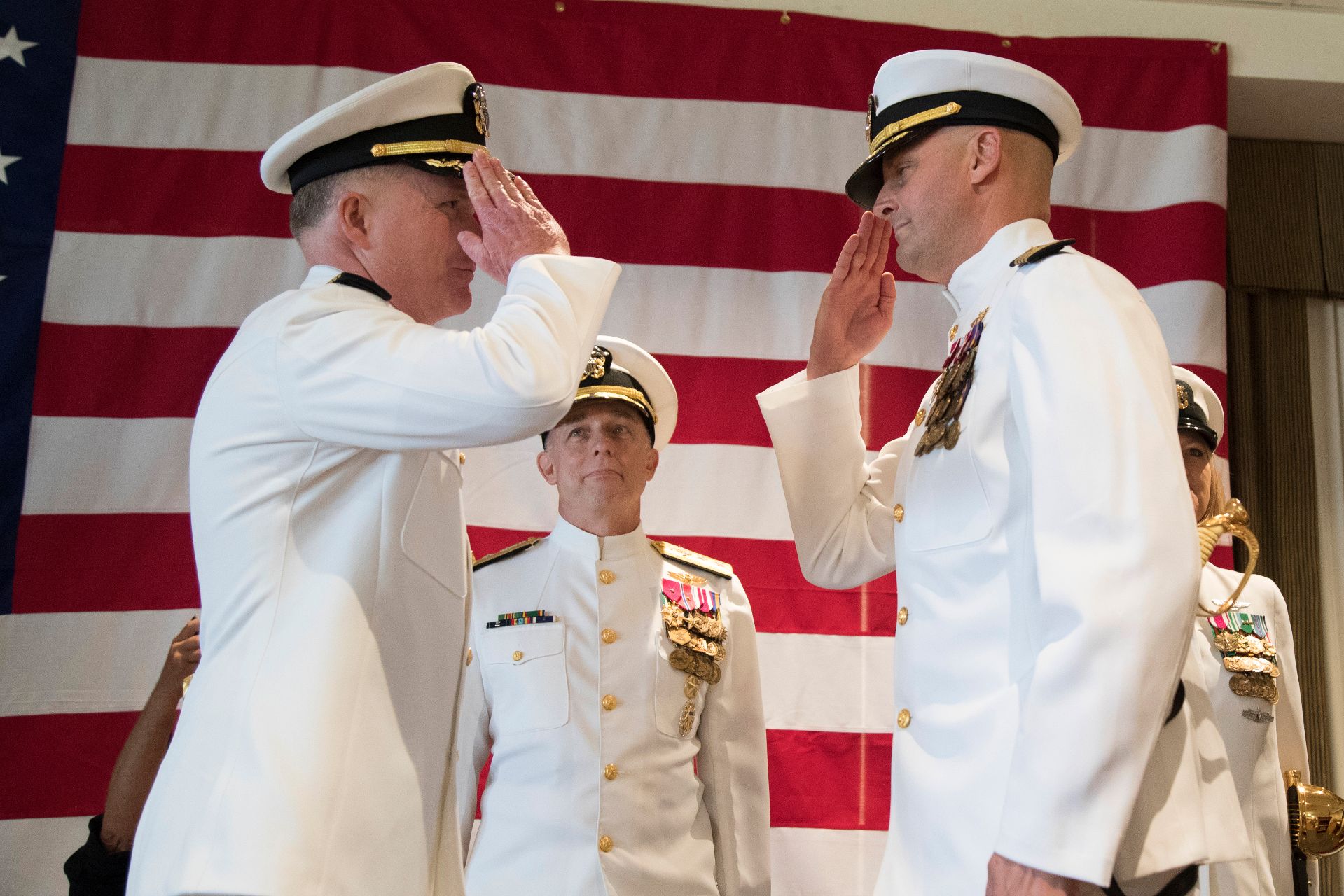 J.J. Cummings '89 (right) assumes command of USS <em>Gerald R. Ford</em> from Capt. Richard C. McCormack during the ship’s change of command ceremony, a time-honored Naval transfer of responsibility, authority, and accountability from one individual to another. (U.S. Navy photo by Mass Communication Specialist 2nd Class Cat Campbell)