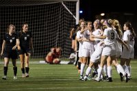 First-year Emma Lombardo celebrates with teammates after finding the back of the net to help lead the Bates women's soccer team to a 2-0 victory over Maine Maritime.