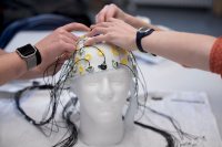 Sarah Rothmann '19 of Andover, Mass., participates as a subject in an EEG neuroscience thesis experiment for a first-person story she is writing for the Bates Communications Office. 

Hanna De Bruyn ‘18, Old Lyme, Conn., is the thesis student who is working on the supervision of Michelle Greene, assistant professor of neuroscience in the Bates Computational Vision Lab (Hathorn 108). 


“We are piloting the experiment for these students’ thesis experiments. They were piloting Hanna’s experiment. She’s interested in looking at the extent to which visual masking actually inhibits perception. So when you take a visual mask, you take an image followed by another image, you’re impaired at understanding the first image. The question is why. So what we’re going to do is take the neural activity that we’re measuring. And the nice thing about EEG is that it measures millisecond by millisecond electrical potentials that are generated in the brain , we measure them from the scalp. And we can see over time what the brain is processing and we use machine learning, we put these signals into a computer system tha t reads out the extent to which there is information about what the picture is. We’re wondering, does that information persist when you change the image? Does that persist over time? Hannah’s made the experiment, and we are going to try it out to make sure everything’s ready for participants.”

-- Michelle Greene, assistant professor of neuroscience, says of three thesis students in neuroscience: “They’re all terrific, I might add.”

Hanna De Bruyn ‘18, Old Lyme, Conn. Katherine “Katie” Hartnett ’18 of St. Paul, Minn., and  Julie Self ’18 of Redwood City, Calif. Hanna is the only student to appear in this set of pictures.