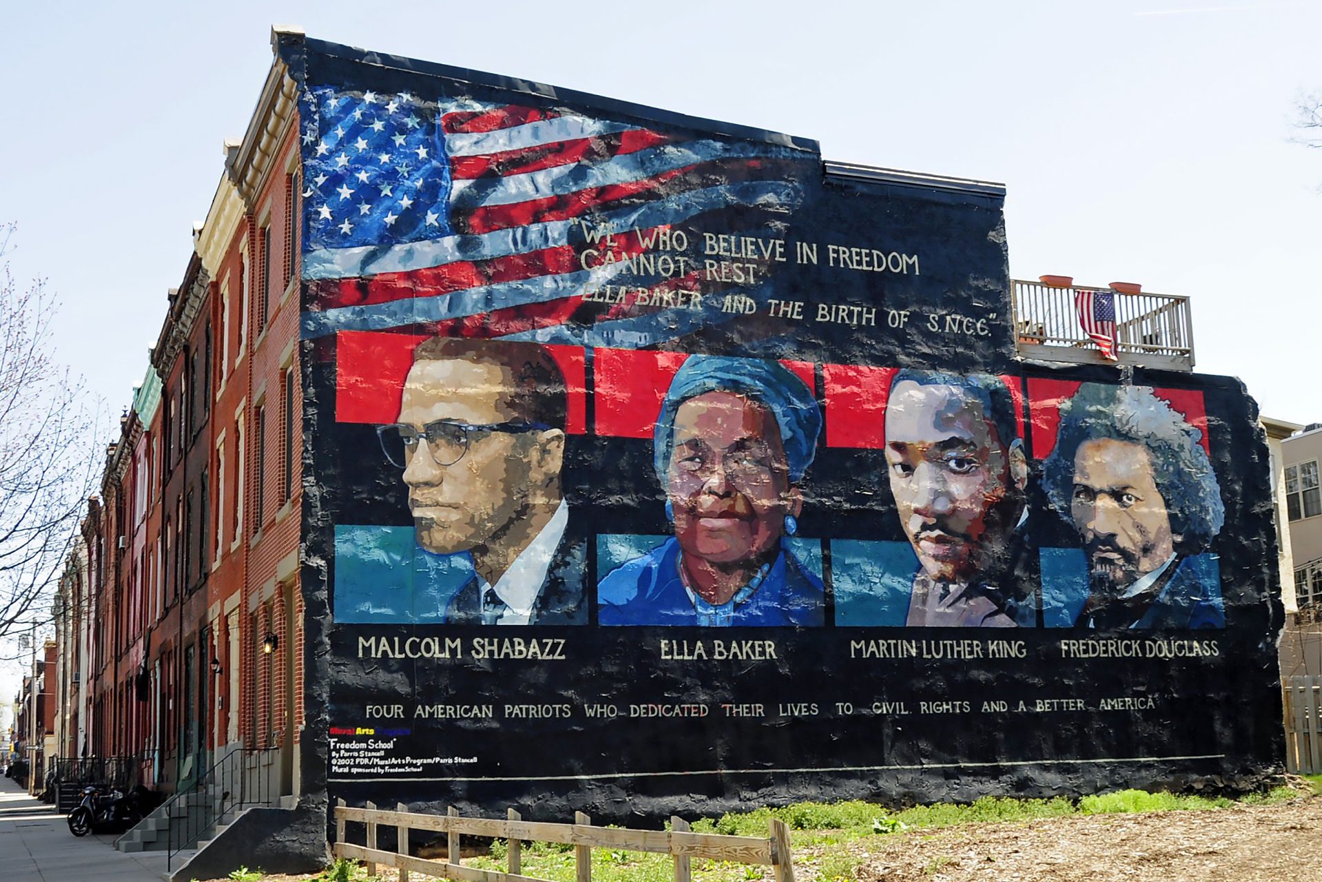 A mural on the wall of row houses in Philadelphia depicts, from left, Malcolm X, Ella Baker, Martin Luther King Jr., and Frederick Douglass. The quote, "We who believe in freedom cannot rest," is from Ella Baker. The mural artist is Parris Stancell. (Tony Fischer [CC BY 2.0 https://creativecommons.org/licenses/by/2.)], via Wikimedia Commons)