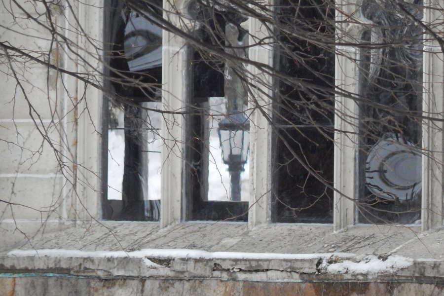 The window openings in the Gomes Chapel have been filled temporarily with polycarbonate panels while the stained glass is being restored. The substitute material is so clear that you can see College Street through the building from the Historic Quad. The tunnel-like shape is a reflection. (Doug Hubley/Bates College)