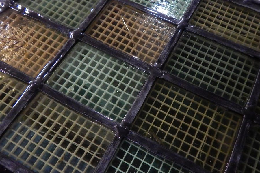 A Gomes chapel ventilator window soaks in a cleaning solution at Phoenix Studio. (Doug Hubley/Bates College)