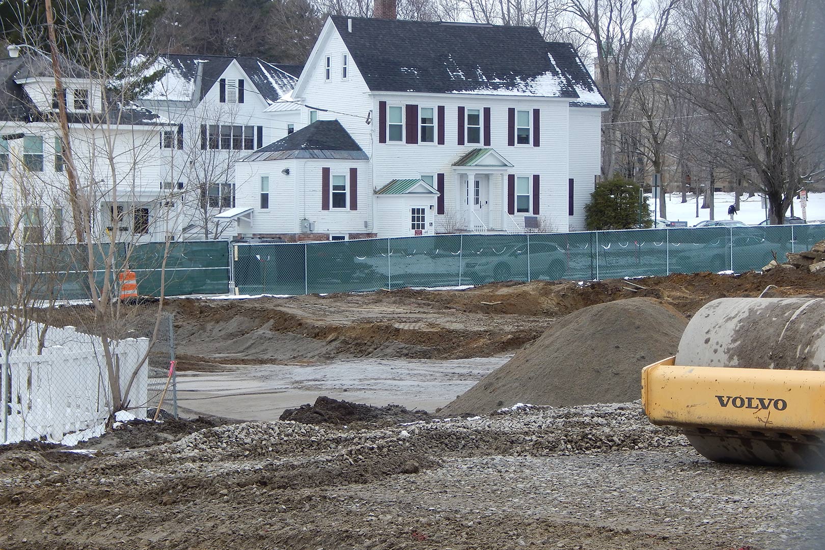 To improve ground stability and drainage, sitework contractor Gendron & Gendron has removed existing soils from the science building site and replaced them with prepared materials such as the gray crushed stone visible in the middle distance. (Doug Hubley/Bates College)