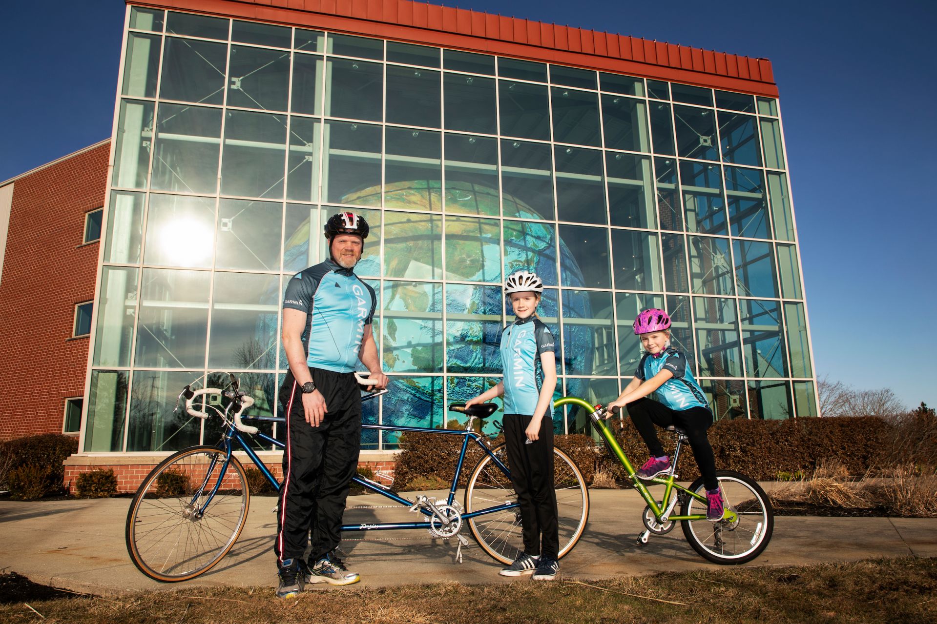 Chip Noble 97 of Yarmouth, and daughter's Abby, 10 and Emma, 7, pose for a portrait outside of Garmin's headquarters in Yarmouth on April 11, 2019.