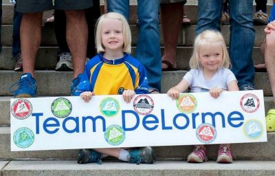 Abby and Emma Noble have been watching, volunteering at, or riding the Trek Across Maine for their whole lives. Here, they're literally the poster children for the riding team at DeLorme, the satellite communications company that was bought by Garmin in 2016. (Courtesy of Chip Noble). 