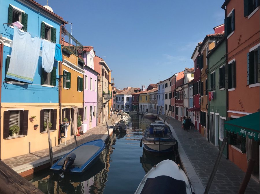 Cruickshank, Sam UVA Valencia This photo was taken during a trip to Italy. This photo specifically comes from Burano, a small island off of Venice. Every home on this island is a different color, and residents must gain approval from the local government before painting their houses. This is to make sure that two homes will never be painted the same color. The cool thing is that people actually live in these houses, as can be seen by the sheets being hung to dry out the window on the left of the image. This photo was selected for the 2019 Barlow Off-Campus Photography Exhibition and shown at the 2019 Mount David Summit on March 29, 2019.