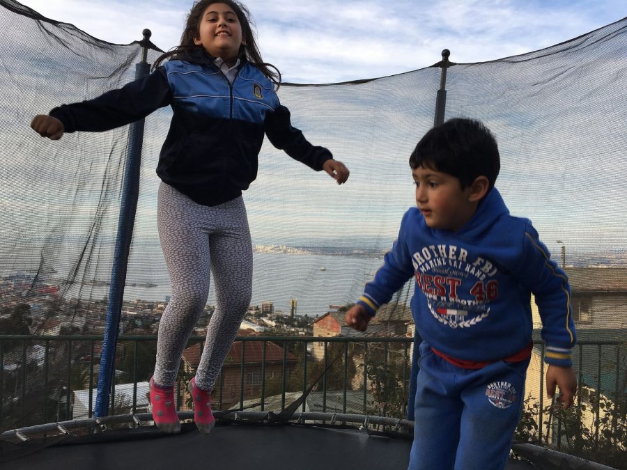 Westwater, Emma SIT Valparaiso Chile Spring 2018 My two host-cousins, Josefa and Alonso, jumping on the trampoline on their grandmother's patio after school on a Friday, which overlooks the city and port of Valparaíso.This photo was selected for the 2019 Barlow Off-Campus Photography Exhibition and shown at the 2019 Mount David Summit on March 29, 2019.