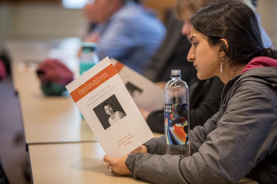 A student peruses the program for April Hill’s April 29 lecture on equity and inclusion in STEM. (Rene Roy for Bates College)