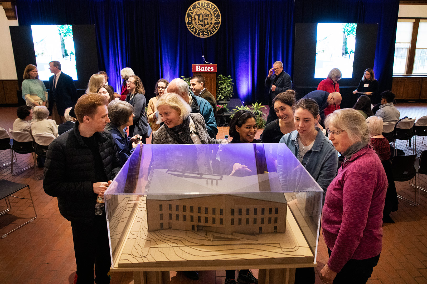 Shortly before the start of a campus-wide celebration of the groundbreaking of the Bonney Science Center on May 2, attendees inspect a model of the building in Memorial Commons. (Theophil Syslo/Bates College)