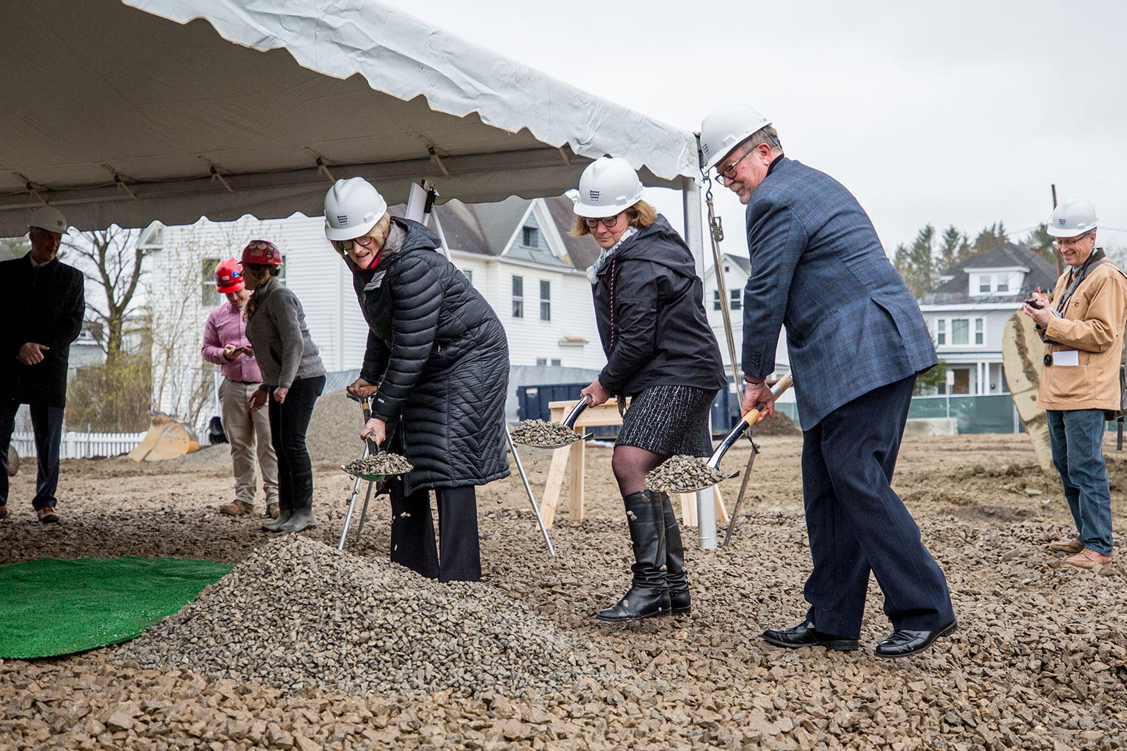 Flinging the ceremonial gravel during the groundbreaking for the Bonney Science are, from left, Bates President Clayton Spencer, Alison Grott Bonney '80, and Michael Bonney '80. At right, a passing stranger takes notes. (Rene Roy for Bates College)