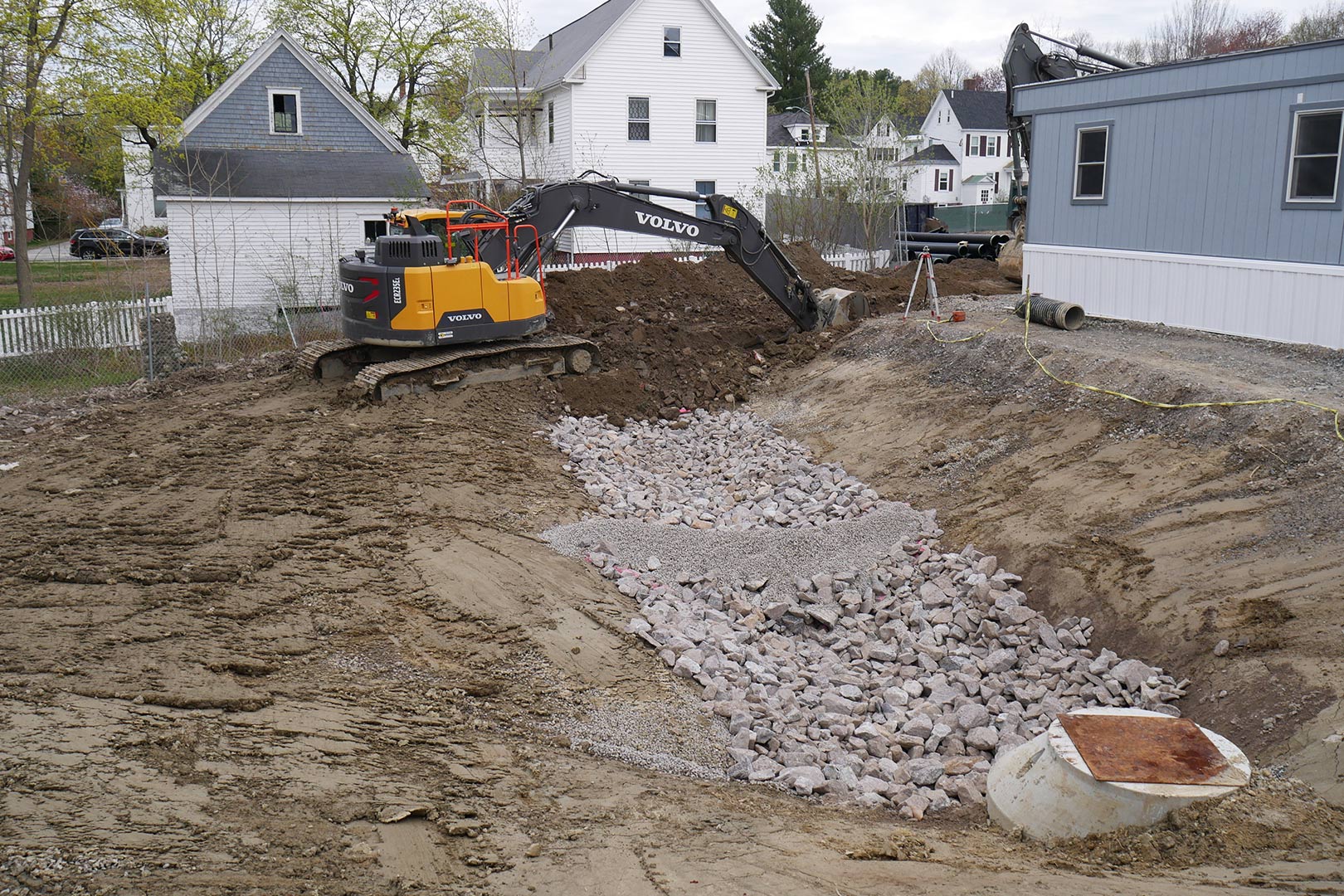 Trenches are being around the Consigli field office to accommodate pipes that will carry water from the science building foundation site to the catchment basin shown here. (Doug Hubley/Bates College)