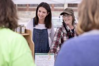 Clio Barr is a STA/RT (SHORT TERM ACTION/RESEARCH TEAM) partner with the Center for Wisdom's Women Herban Works. Her project title is Creating Marketing Materials and a Business Plan for Sophia's House.On the first spring day of the 2019 Lewiston Farmer's Market, Barr sells products on Sunday, May 12, with Judy Maloneygarden and production coordinator and volunteer Mary Hopkins, who also helps with harvesting and planting.