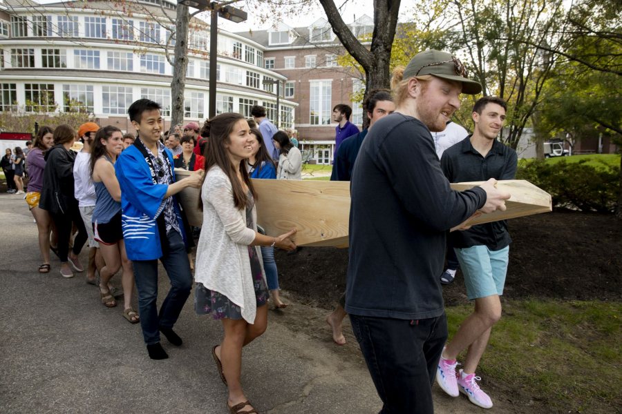 Students carry one of the boats to the water. (Phyllis Graber Jensen/Bates College)