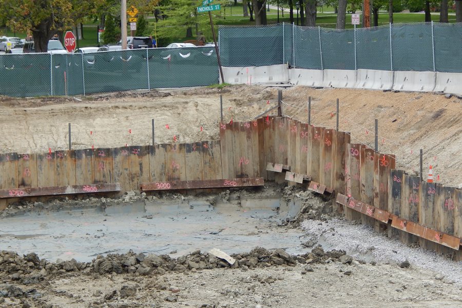 With the Historic Quad in the distance, this view of the northwest corner of the science building site shows how sections of beam are used to reinforce the retaining wall. (Doug Hubley/Bates College)