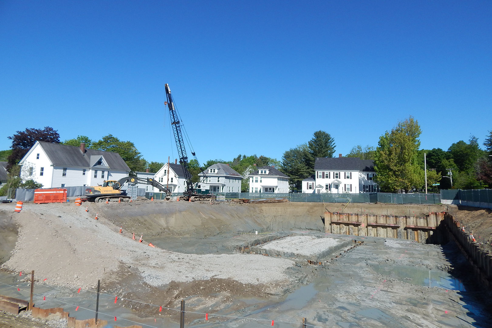 The construction site is quiet at mid-morning on June 7, the Friday of Reunion 2019. Note the tops of the sheet piles barely visible around the rectangle in the foundation hole: That spot will be dug down another eight feet or so. (Doug Hubley/Bates College)