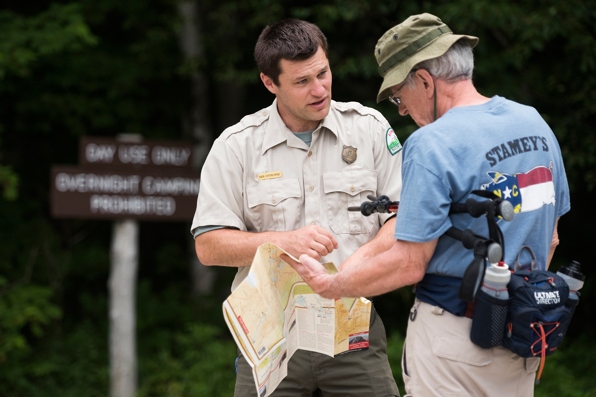 Baxter State Park, Maine—08-03-2018— Eben Sypitlowski helps park visitor Tom Fegley of Germantown Maryland at Abol Stream parking lot on Friday. Fegley is a first time visitor and was asking about a washed out bridge close by.Kevin Bennett Photo