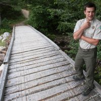 Baxter State Park, Maine—08-03-2018— Eben Sypitlowski waits to cross a snowmobile bridge at Abol Stream on his way to inspect recent trail improvements at Baxter State Park on Friday. Kevin Bennett Photo