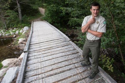 Baxter State Park, Maine—08-03-2018— Eben Sypitlowski waits to cross a snowmobile bridge at Abol Stream on his way to inspect recent trail improvements at Baxter State Park on Friday. Kevin Bennett Photo