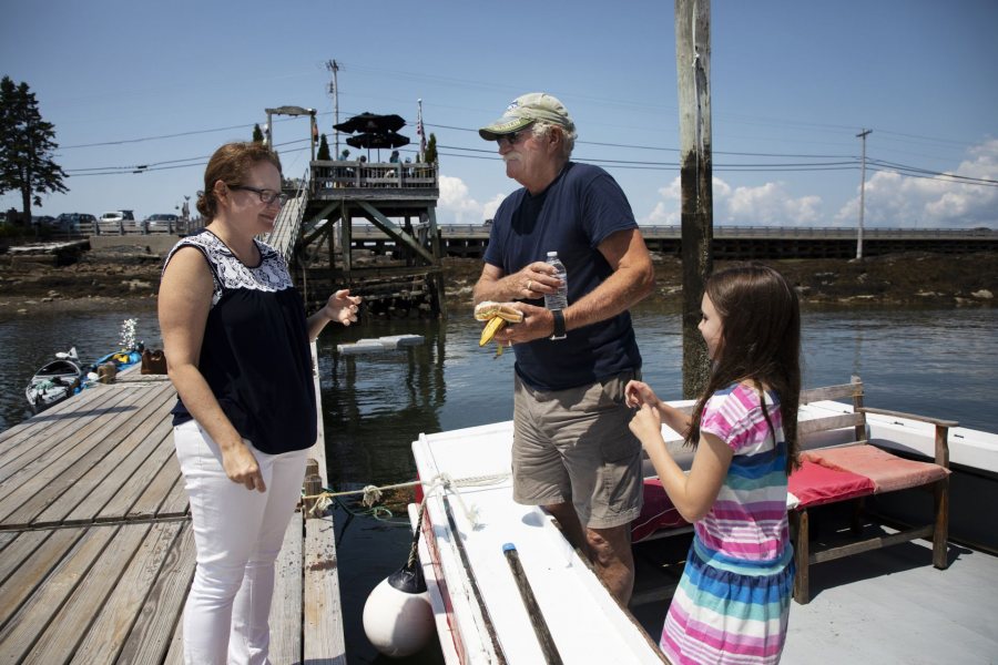 Kate McGowen Wing, '01, and her father Captain Jay McGowen, and daughter Tessa Wing, 8, of West Wind Lobster Tours in Bailey Island, interact in between tours on July 26, 2019.